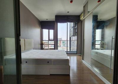 Spacious modern bedroom with large bed and balcony view