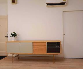 Modern living area with wooden sideboard and air conditioning