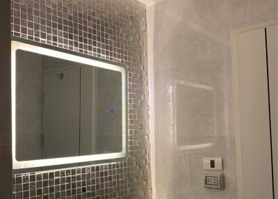 Modern bathroom with illuminated mirror and mosaic tiles