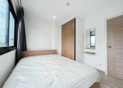 modern bedroom with large bed, wardrobe, mirror and window