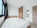 modern bedroom with large bed, wardrobe, mirror and window