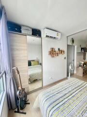 Modern bedroom with a large window, air conditioning, and a guitar