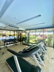 Modern gym with exercise equipment and large windows