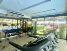 Modern gym with exercise equipment and large windows