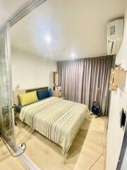 Bedroom with bed, striped bedding, guitar, and air conditioner