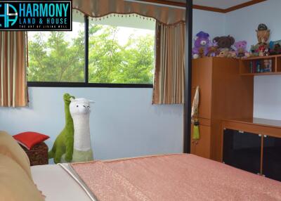 Cozy bedroom with a large window, soft toys, and wooden furniture