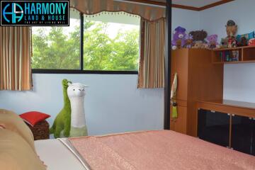 Cozy bedroom with a large window, soft toys, and wooden furniture