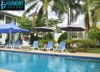 Outdoor pool area with lounge chairs and umbrellas