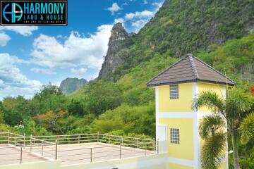 Exterior view of a building with surrounding mountains and greenery