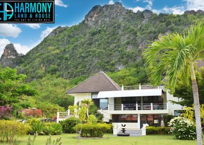 Exterior view of Harmony Land & House property with surrounding greenery and mountains