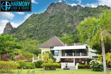 Exterior view of Harmony Land & House property with surrounding greenery and mountains