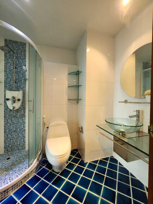 Modern bathroom with glass shower, toilet, and sink