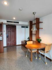 Dining area with wooden table, chairs, and pendant light