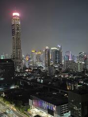 Night view of a city skyline with high-rise buildings and colorful lights