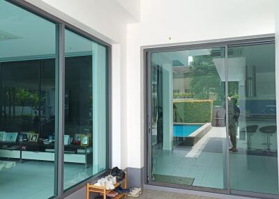 Outdoor patio area with glass doors and view of pool