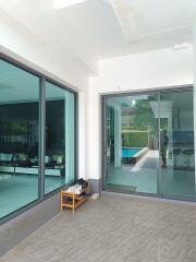 Outdoor patio area with glass doors and view of pool