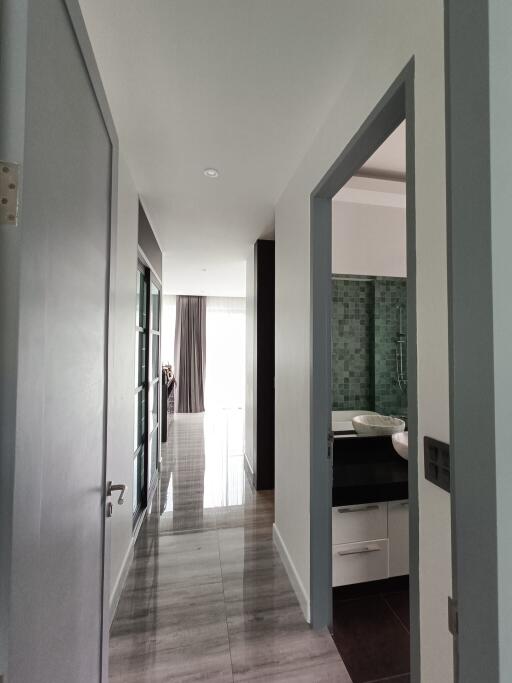 Modern hallway leading to other rooms with a view of bright natural lighting