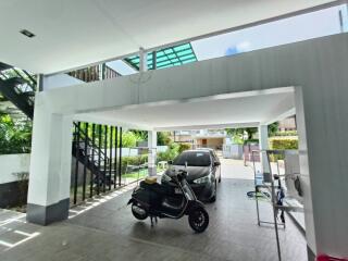 Covered garage space with motorcycle and car