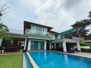 Modern two-story house with a swimming pool and outdoor seating area