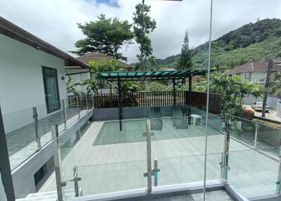 Outdoor patio with glass railing and trees