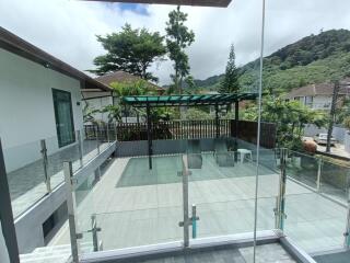 Outdoor patio with glass railing and trees