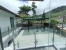 Outdoor patio with glass railing and trees