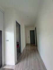 Bright hallway with wooden floor leading to multiple rooms