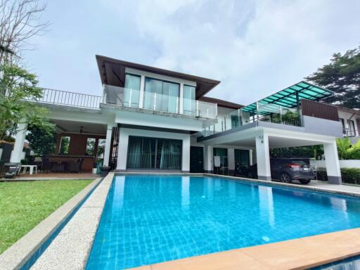 Exterior view of a modern house with a swimming pool and a patio area