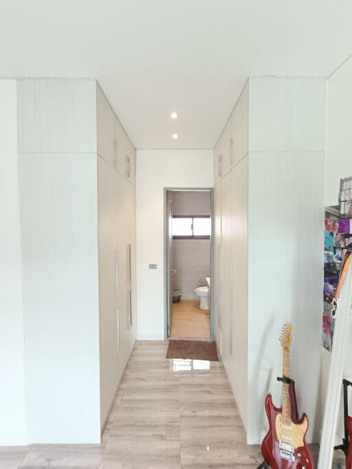 Hallway with visible bathroom entrance and guitar