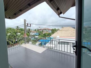 Spacious balcony with a view of houses and greenery