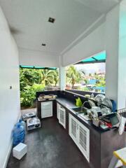 Outdoor kitchen with white cabinetry and green views