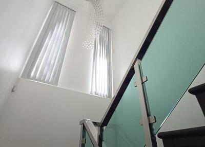 Modern staircase with glass balustrade and chandelier