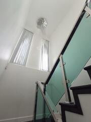 Modern staircase with glass balustrade and chandelier
