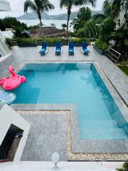 outdoor pool with lounge chairs and scenic view