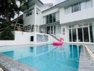 Outdoor pool area with modern white building