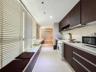 Modern kitchen with white countertops, dark cabinets, and large windows