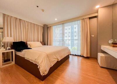 Spacious bedroom with large windows and hardwood floor