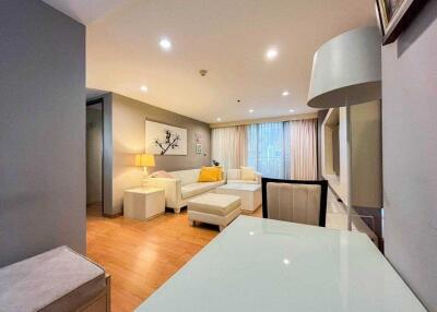 Modern living room with comfortable seating, artwork and ample lighting