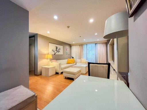 Modern living room with comfortable seating, artwork and ample lighting