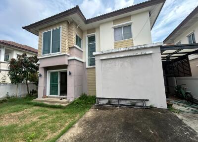 Exterior view of a two-story house with a driveway and small lawn