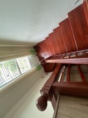 Wooden staircase with railing and window