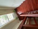 Wooden staircase with railing and window