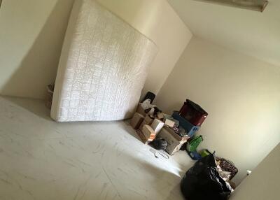 Unfurnished room with belongings and a mattress against the wall