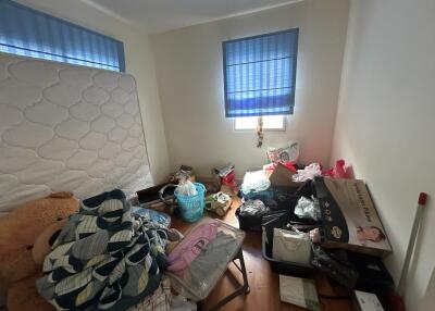 Cluttered bedroom with scattered items and minimal furniture