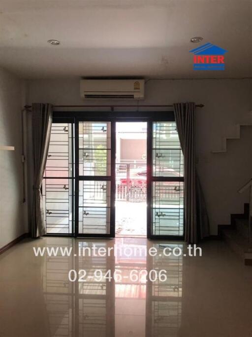 View of a living room with large window and metal door