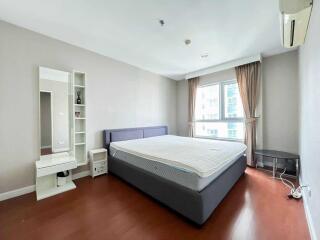 Modern bedroom with large window, bed, and vanity