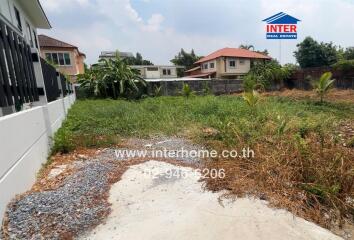 Empty lot with surrounding houses and greenery