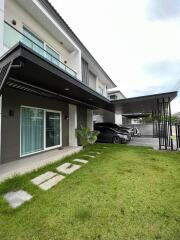 Modern two-story house exterior with garden and driveway