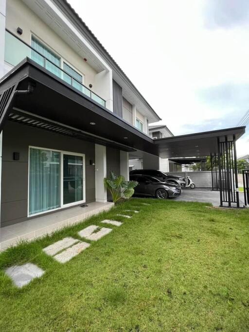 Modern two-story house exterior with garden and driveway