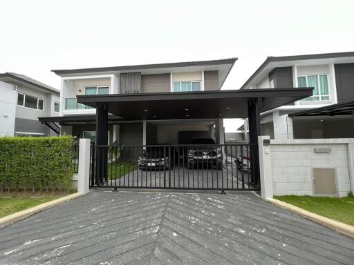Exterior view of a modern two-story house with a carport and driveway